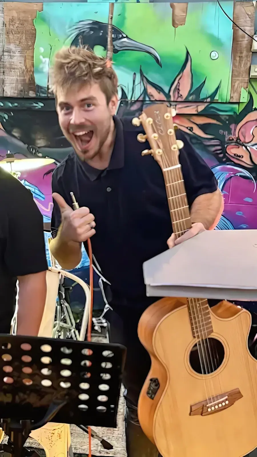 Damien Hill giving a thumbs up before a student guitar performance in Townsville