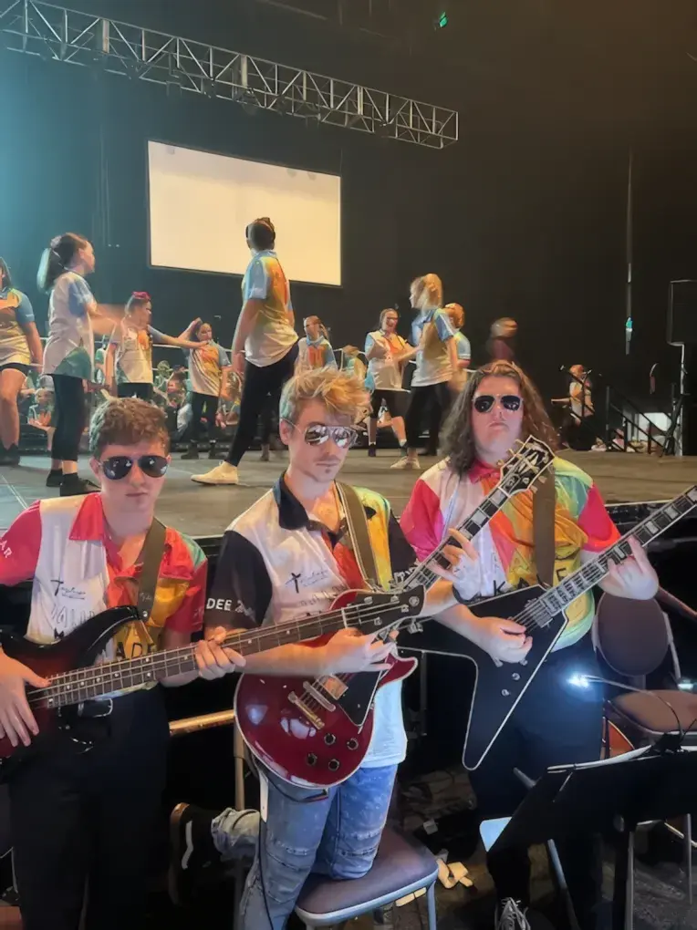 Damien Hill with guitar students on stage at the Mulkadee Youth Arts Festival in Townsville